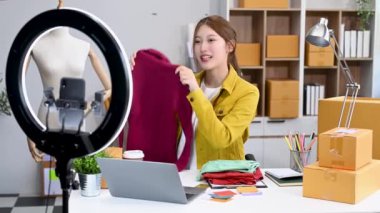 Moda blogcusu konsepti, Asyalı genç bir kadın akıllı telefondan video yayını yapıyor. 