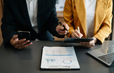 İş ekibi toplantısı. Finans yöneticileriyle çalışan profesyonel yatırımcılar grafiklere bakıyor ve bilgisayarları, akıllı telefonlu tabletleri kullanıyorlar.