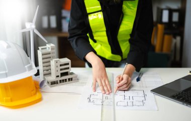 Modern ofisteki inşaat sahasında mimari projeyle büyük çizimlere yansıyan yaratıcı mimarlar