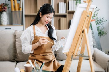 Sanat atölyesinde resim yapan Asyalı kadın ressam, boya malzemeleri, yağ boyaları, sanat stüdyosunda yaratıcı alan kullanıyor. 