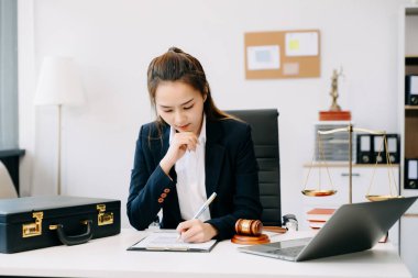 Adalet ve hukuk kavramı. Mahkeme salonundaki kadın yargıç tokmak, belgeler ve dizüstü bilgisayarla çalışıyor.