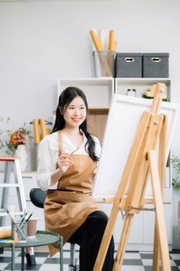 Sanat atölyesinde resim yapan Asyalı kadın ressam, boya malzemeleri, yağ boyaları, sanat stüdyosunda yaratıcı alan kullanıyor. 