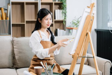 Sanat atölyesinde resim yapan Asyalı kadın ressam, boya malzemeleri, yağ boyaları, sanat stüdyosunda yaratıcı alan kullanıyor. 