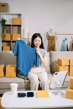 Başlangıçta küçük işletme KOBİ 'si, dijital tablet kullanan girişimci kadın, ürün kutularının hazırlanması için çevrimiçi alışveriş siparişi alıp kontrol ediyor 