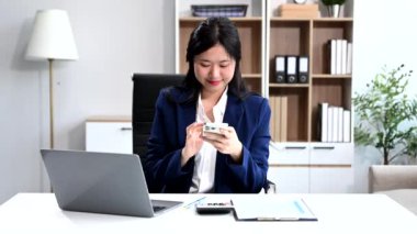 İş kadını ofisteki bir ofiste matematik finansmanı için telefon ve laptop kullanıyor.