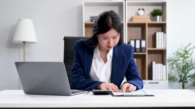İşkadını ofisteki bir ofiste dizüstü bilgisayarla matematik finansmanı yapıyor.