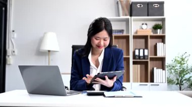 Ofisteki bir ofiste matematik finansmanı için tablet bilgisayar kullanan bir iş kadını