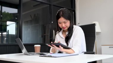 Ofisteki bir ofiste matematik finansmanı için tablet bilgisayar kullanan bir iş kadını