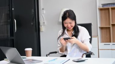 İş kadını ofisteki bir ofiste matematik finansmanı için telefon ve laptop kullanıyor.