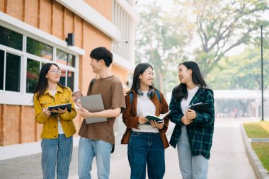 Üniversite öğrencileri sabahları kampüs parkında dijital tablet ve dizüstü bilgisayarla çalışıyorlar. 