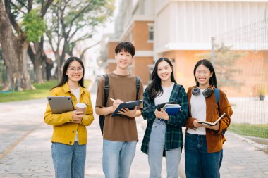 Üniversite öğrencileri sabahları kampüs parkında dijital tablet ve dizüstü bilgisayarla çalışıyorlar. 