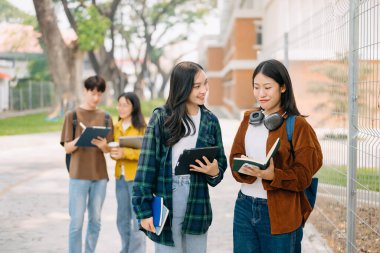 Üniversite öğrencileri sabahları kampüs parkında dijital tabletle çalışıyorlar. 