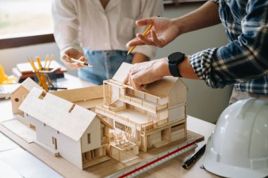 Mimarlarla dolu bir masayı yakından çek. İki mimar ofiste mimari model oluşturuyorlar..