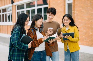 Üniversite öğrencileri sabahları kampüs parkında dijital tablet ve dizüstü bilgisayarla çalışıyorlar. 