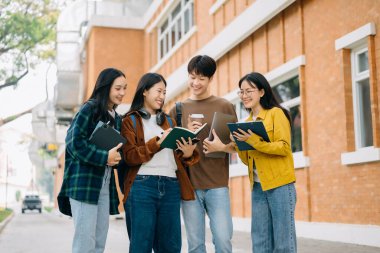 Üniversite öğrencileri sabahları kampüs parkında dijital tablet ve dizüstü bilgisayarla çalışıyorlar. 