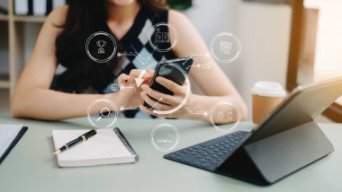 Ofiste çalışan iş kadınları, ofiste akıllı telefon ve tablet bilgisayar kullanıyorlar.