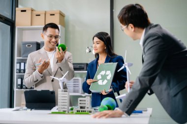 İşletme ekibi, dizüstü bilgisayar ve dijital tablet kullanarak, geri dönüşüm planlama ve tartışması ofis toplantı odasında yeniden kullanım politikası sembolünü azaltır 