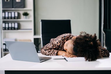 Çok çalışan genç işkadını ofis çalışanı yorucu bir günün ardından ofis masasında uyuyor. ofis sendromu kavramı