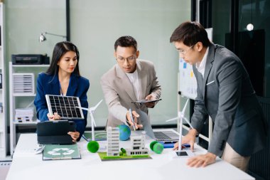 İş adamlarının şirket ofisinde rüzgar enerjisi hakkında görüşleri var. İş ekibi yel değirmenleri ve alternatif yeşil enerji hakkında tartışıyor