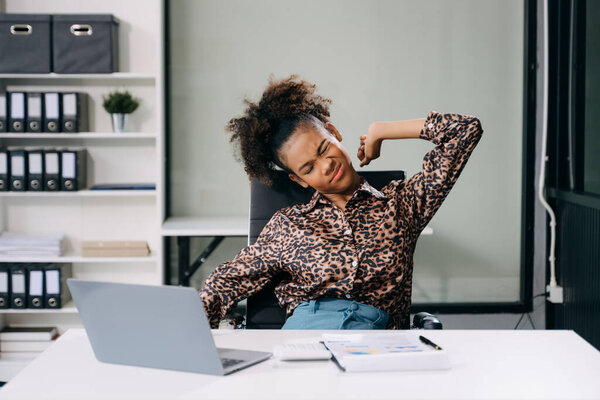 Overworked young businesswoman office worker stretching after hard a long day at office desk. office syndrome concept