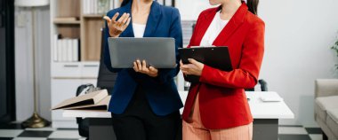 Ofiste dizüstü bilgisayar kullanan iki iş kadını. 