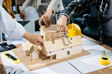 Mühendis ekibi, modern şehir modelinin çalışma alanının planlarıyla toplantıda.