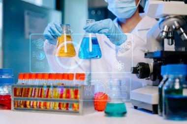 Kadın bilim adamı biyoteknoloji uzmanı bir laboratuarda yeni kimyasal maddeler test ediyor.