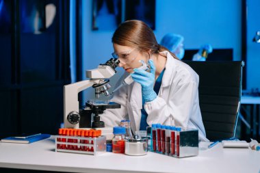 Modern tıbbi araştırma laboratuvarı. Kadın bilim adamı mikro pipetlerle çalışıyor biyokimyasal örnekleri analiz ediyor, ileri bilim kimya laboratuvarı 