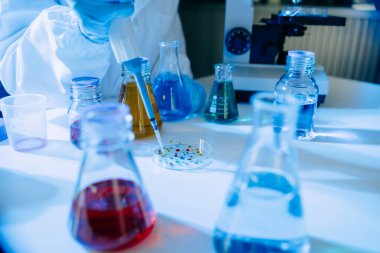 Kadın bilim adamı biyoteknoloji uzmanı bir laboratuarda yeni kimyasal maddeler test ediyor.