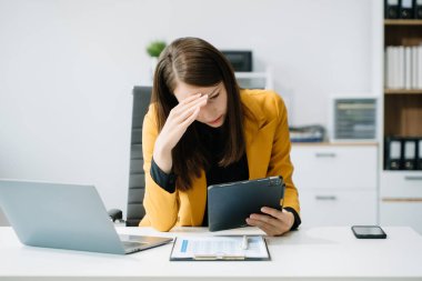 İş kadını migren ağrısı çekiyor. Ofiste dijital tablet kullanan çok çalışan girişimci.
