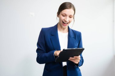 Beyaz arka planda izole edilmiş dijital tablet kullanan kendine güvenen beyaz iş kadını