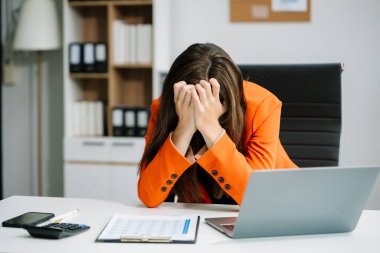 Ofis masasında uzun bir gün geçirdikten sonra baş ağrısından muzdarip çok çalışan bir ofis çalışanı. ofis sendromu kavramı