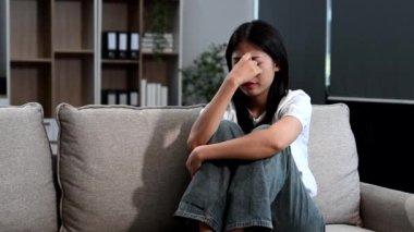 Kanepede oturan depresyondaki Asyalı kadın.