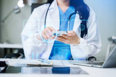 Kadın doktor dizüstü bilgisayar ve akıllı telefon kullanıyor. Sanal ekranlı dijital sağlık hizmeti kavramı, tıbbi teknoloji.