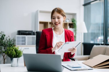 Ofiste dijital tablet reklam dizüstü bilgisayarı üzerinde çalışan Asyalı iş kadını 