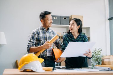 Mimari proje sahasında mühendislik ekibi çalışıyor ve modern ofiste model ev yapıyorlar. 