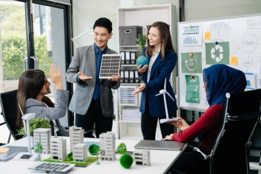 İş adamlarının şirket ofisinde rüzgar enerjisi hakkında görüşleri var. İş ekibi yel değirmenleri ve alternatif yeşil enerji hakkında konuşuyor. Ofiste yönetici toplantısı. 