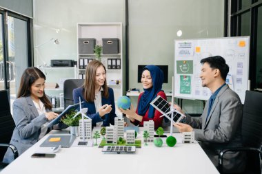 İş adamlarının şirket ofisinde rüzgar enerjisi hakkında görüşleri var. İş ekibi yel değirmenleri ve alternatif yeşil enerji hakkında konuşuyor. Ofiste yönetici toplantısı. 