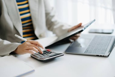 İş kadını elleri ofiste dijital tablet bilgisayar ve dizüstü bilgisayarla çalışıyor.