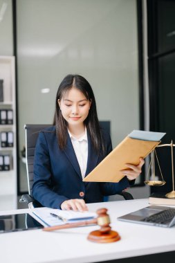 Ofiste dizüstü bilgisayarla çalışan Asyalı güzel bir avukat. Adalet ve hukuk konsepti