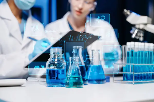 stock image Young scientists conducting research investigations in a medical laboratory, a researchers using a microscope and digital tablet in laboratory for medicine.  