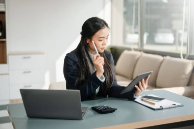 Ofiste dijital tablet reklam dizüstü bilgisayarı üzerinde çalışan Asyalı iş kadını 
