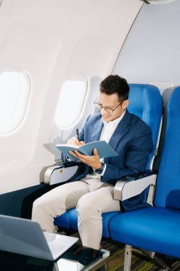 Genç Asyalı yönetici dizüstü bilgisayar ve not defteriyle birinci sınıfta başarılı oldu  