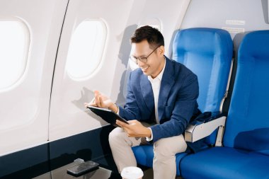 Genç Asyalı yönetici dijital tablet ve telefonla birinci sınıfta başarılı oldu 