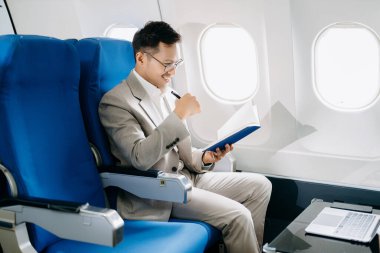 Genç Asyalı yönetici dizüstü bilgisayar ve not defteriyle birinci sınıfta başarılı oldu  