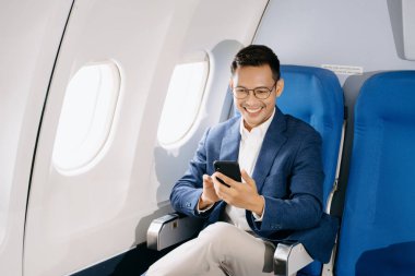 Genç Asyalı yönetici akıllı telefonuyla birinci sınıfta sivrildi