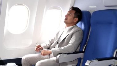 Genç Asyalı yönetici birinci sınıfta dizüstü bilgisayar ve kahvede başarılı.. 