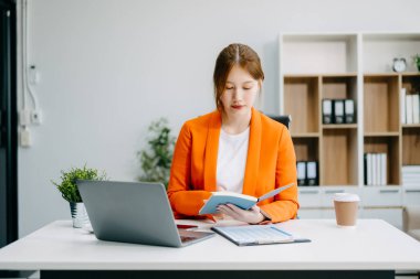 Başarılı Asyalı İş Kadını Not Defterine Analiz Notları ve modern Ofis Masa Vergisi, Raporu, Muhasebe, İstatistikler ve Analitik Araştırma Konsepti 'nde dizüstü bilgisayar kullanımı