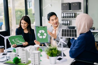 Çok ırklı iş adamlarından oluşan bir grup, konut projesinden bir yapı modeline bakıyor. Yeşil iş şirketi ve Güneş Enerjisi Çevre Kenti Kavramı.