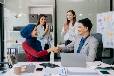 İş ortaklığı tokalaşması. Çok ırklı takım arkadaşları el sıkışma sürecinde. Büyük toplantıdan sonra başarılı bir anlaşma..